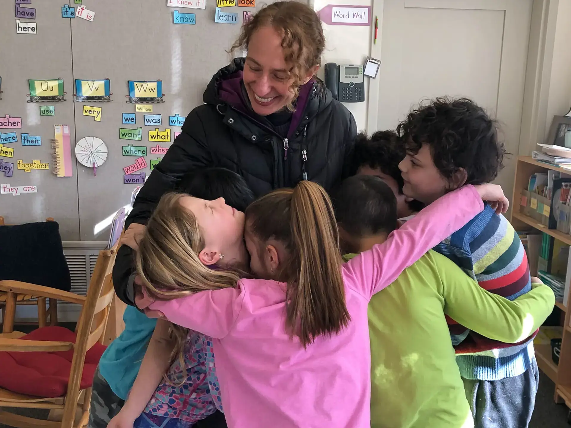 Students ansd teacher in group hug