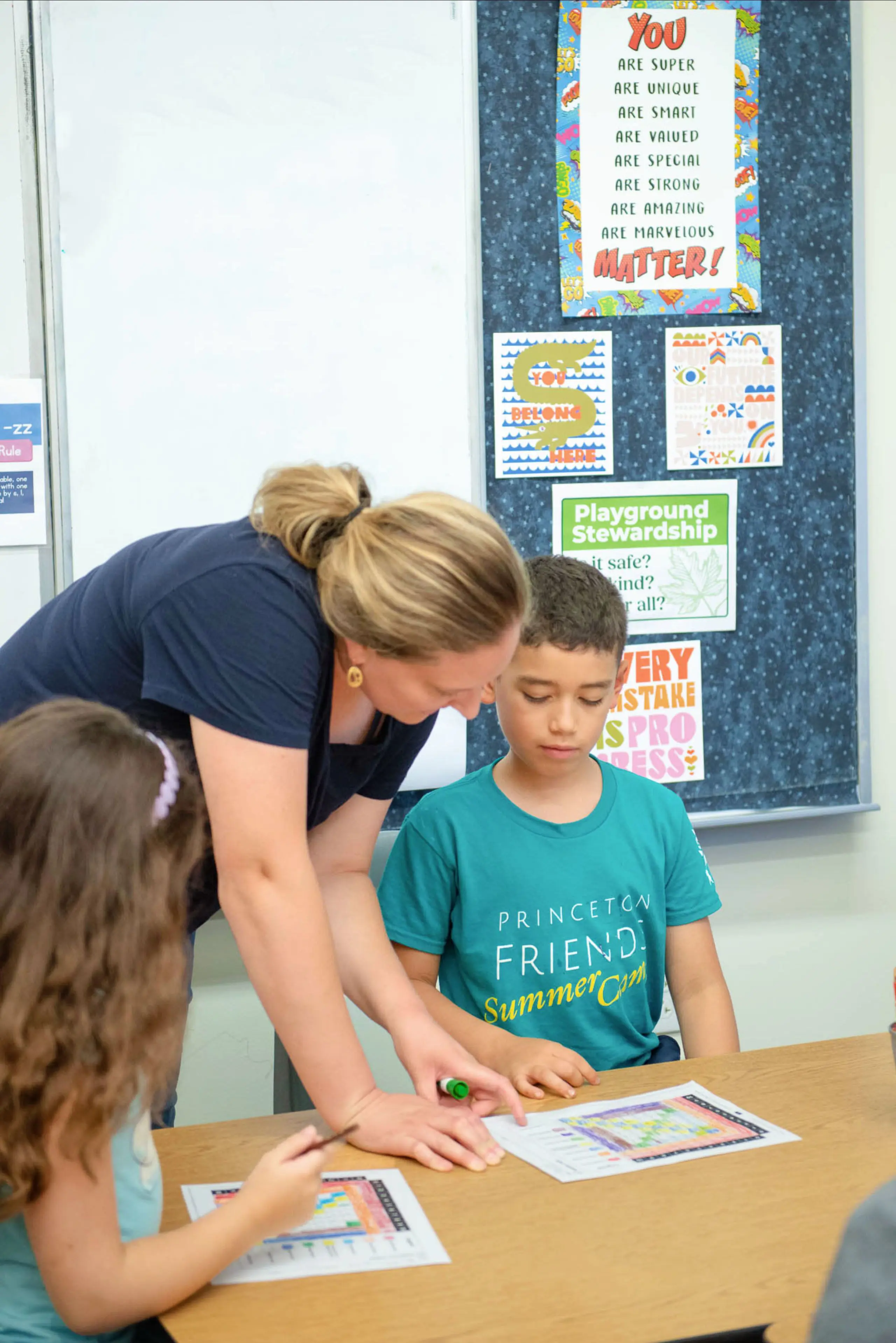Teacher helping child in classroom