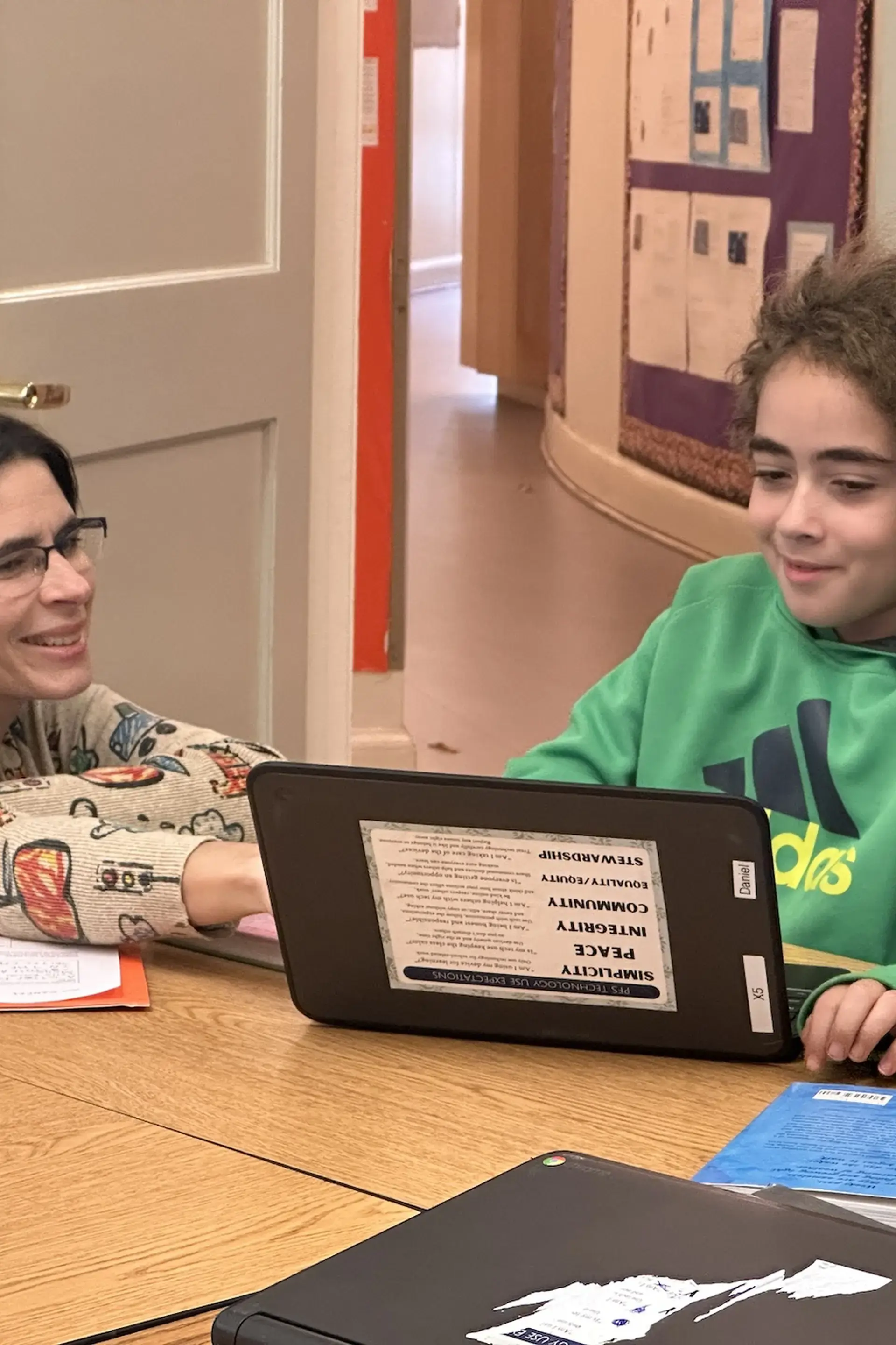 Student and teacher looking at a laptop