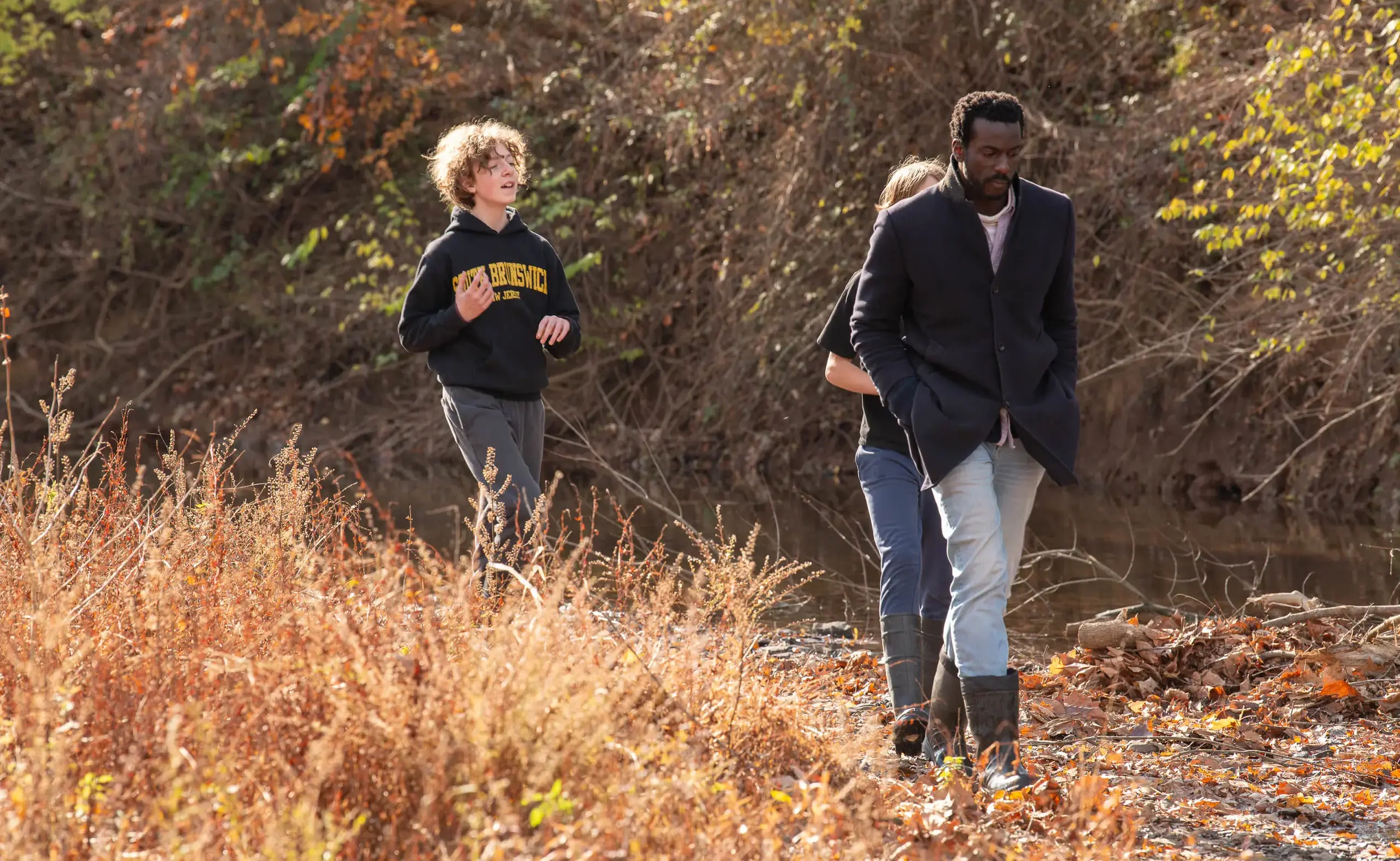 students and teacher walk along the stream