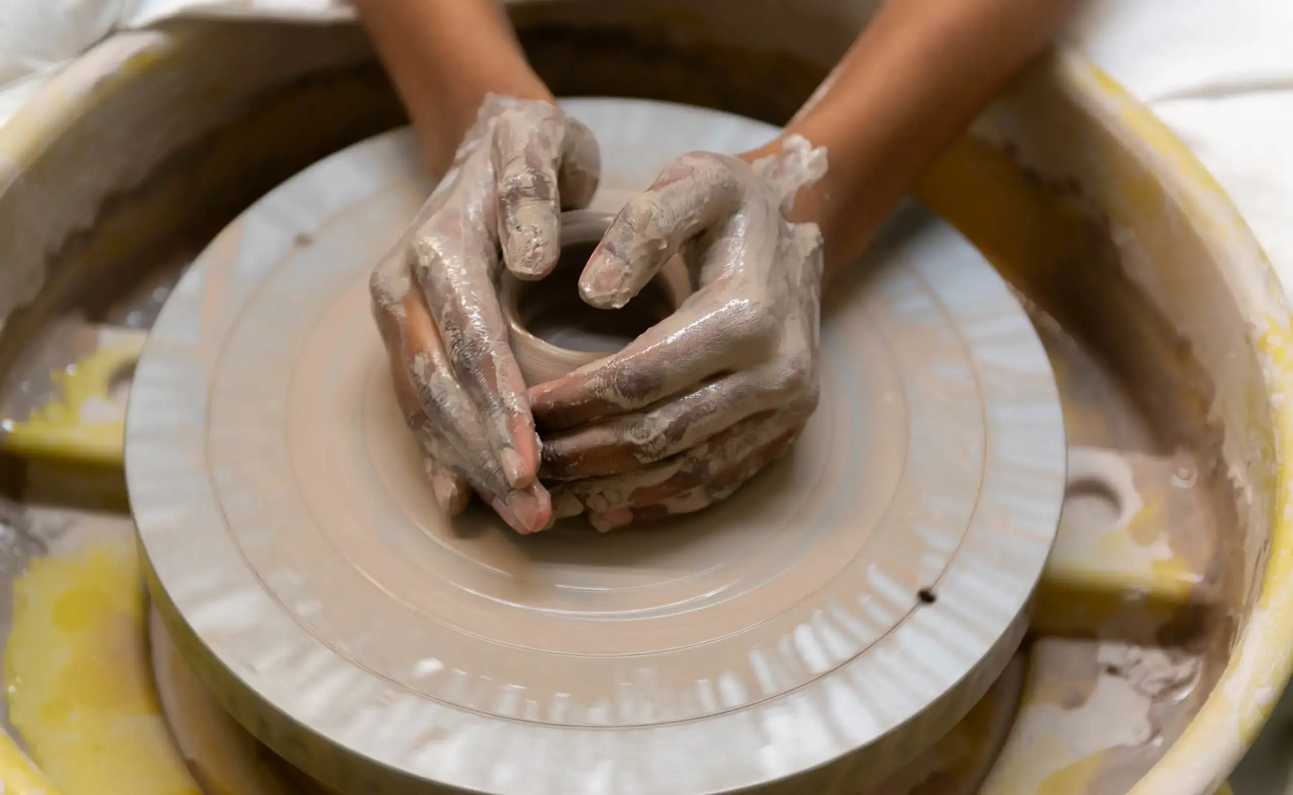 Hands working pottery clay