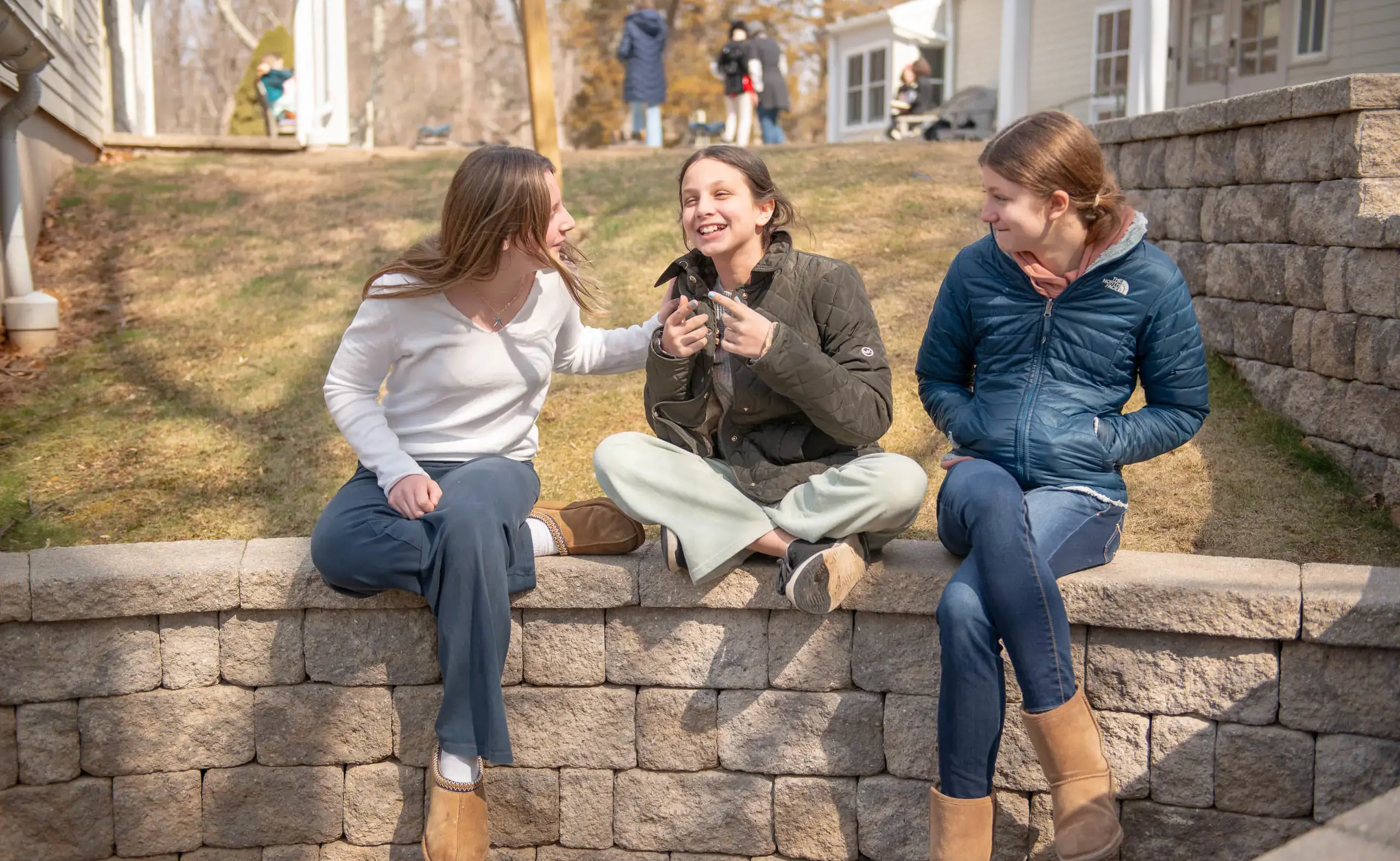Three students sitting on a wall