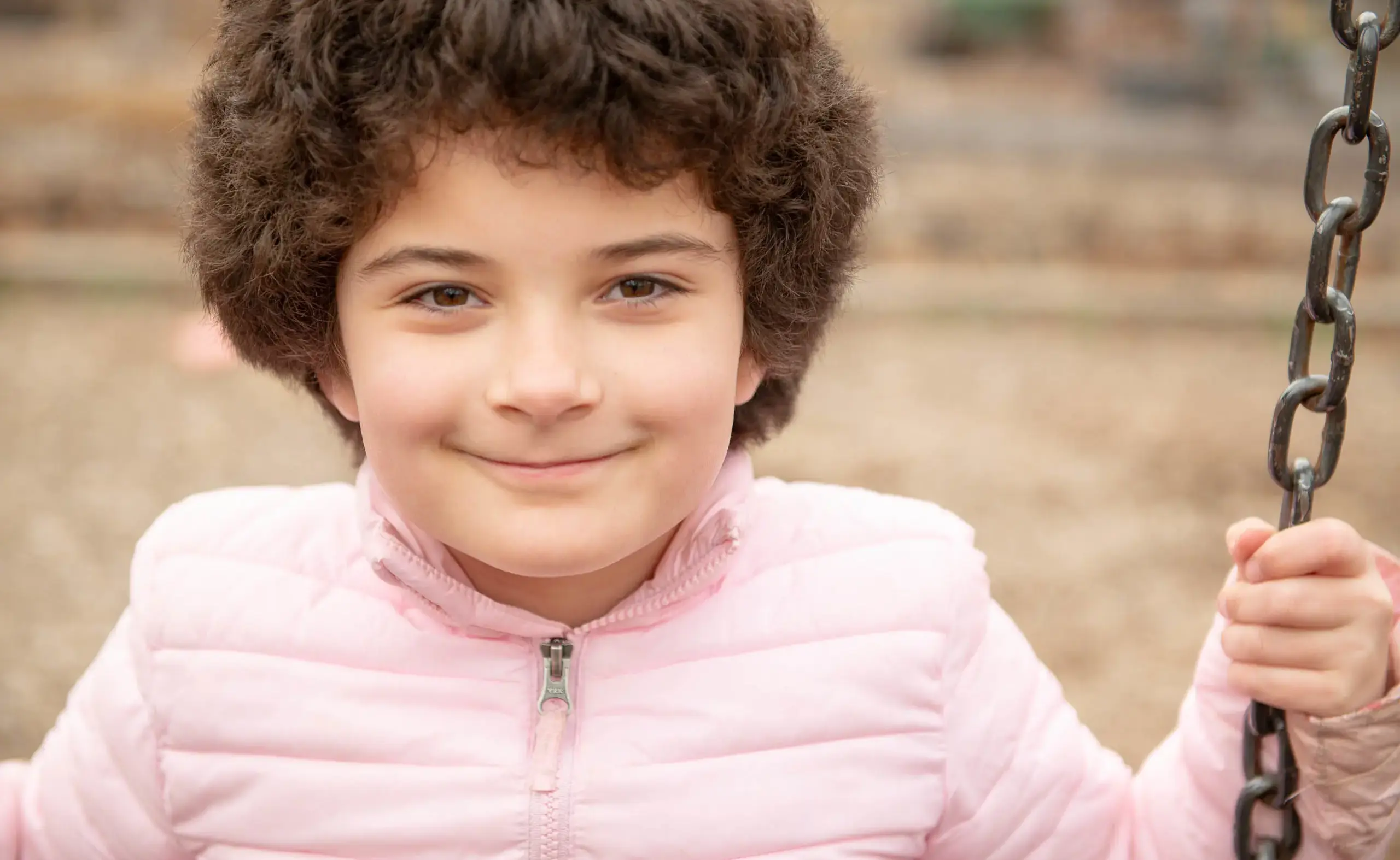 Smiling student sitting on swing