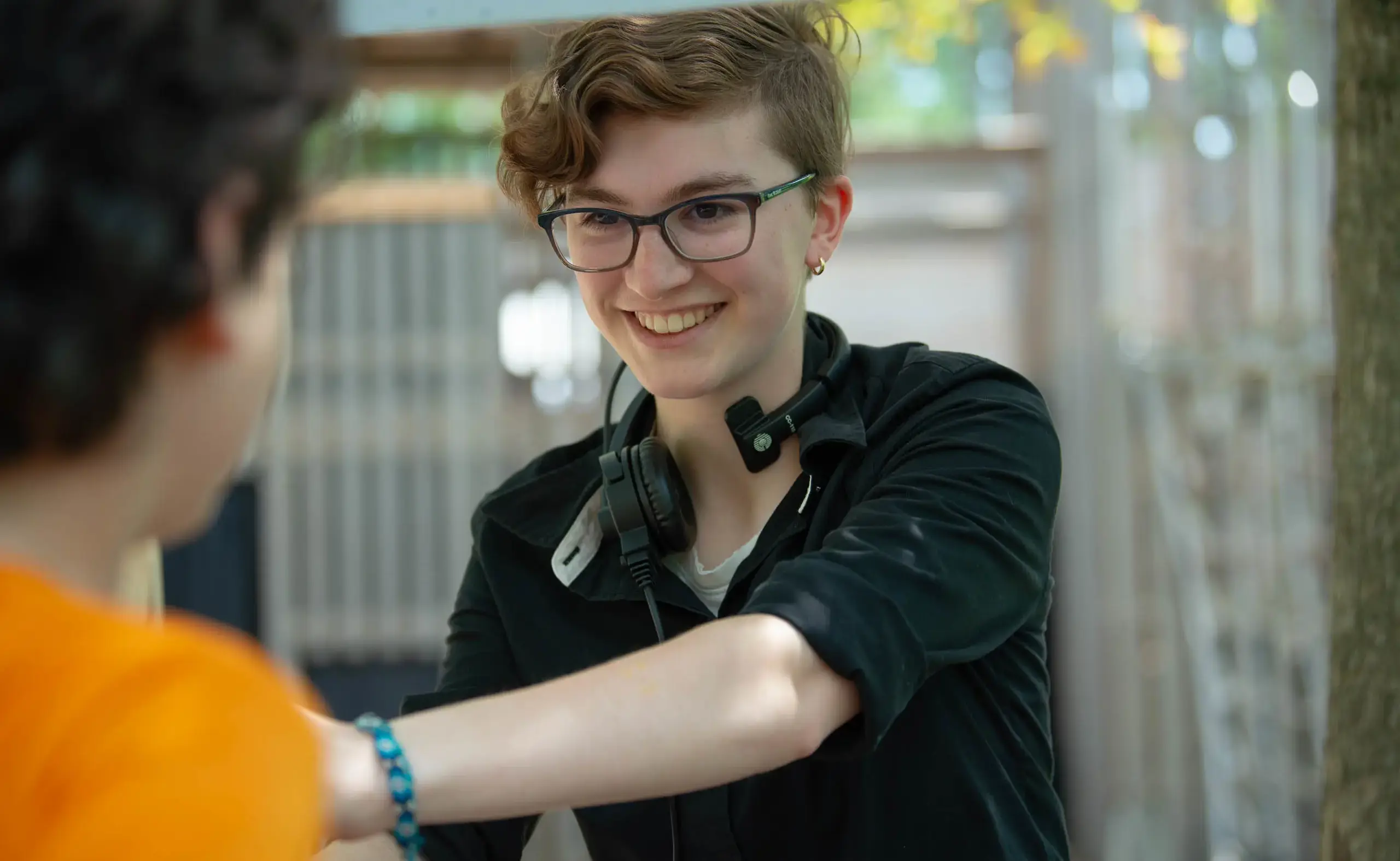 Smiling student wearing headphones around neck