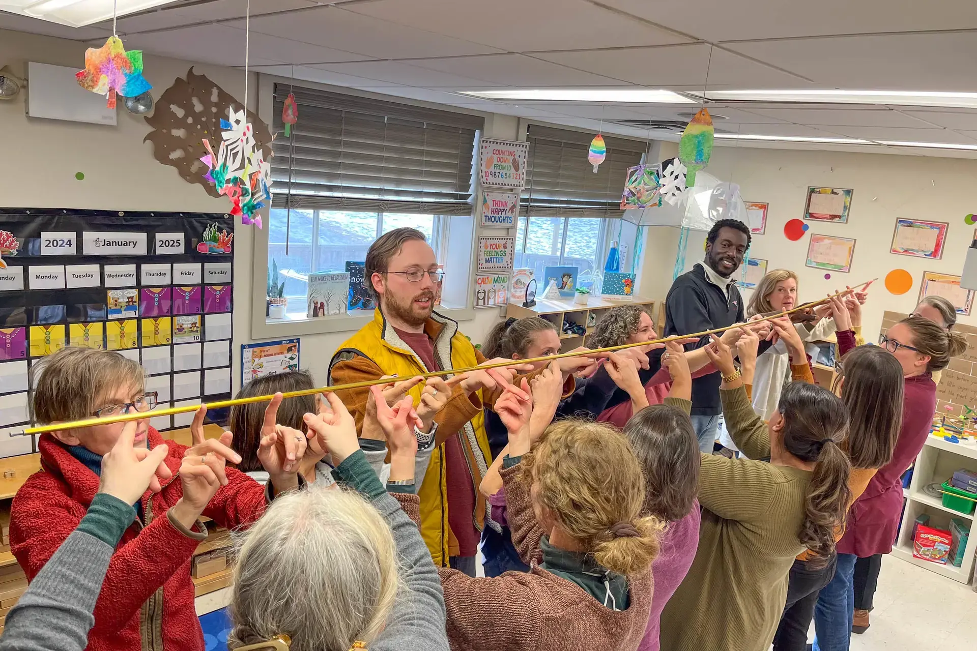 Faculty holding up long stick