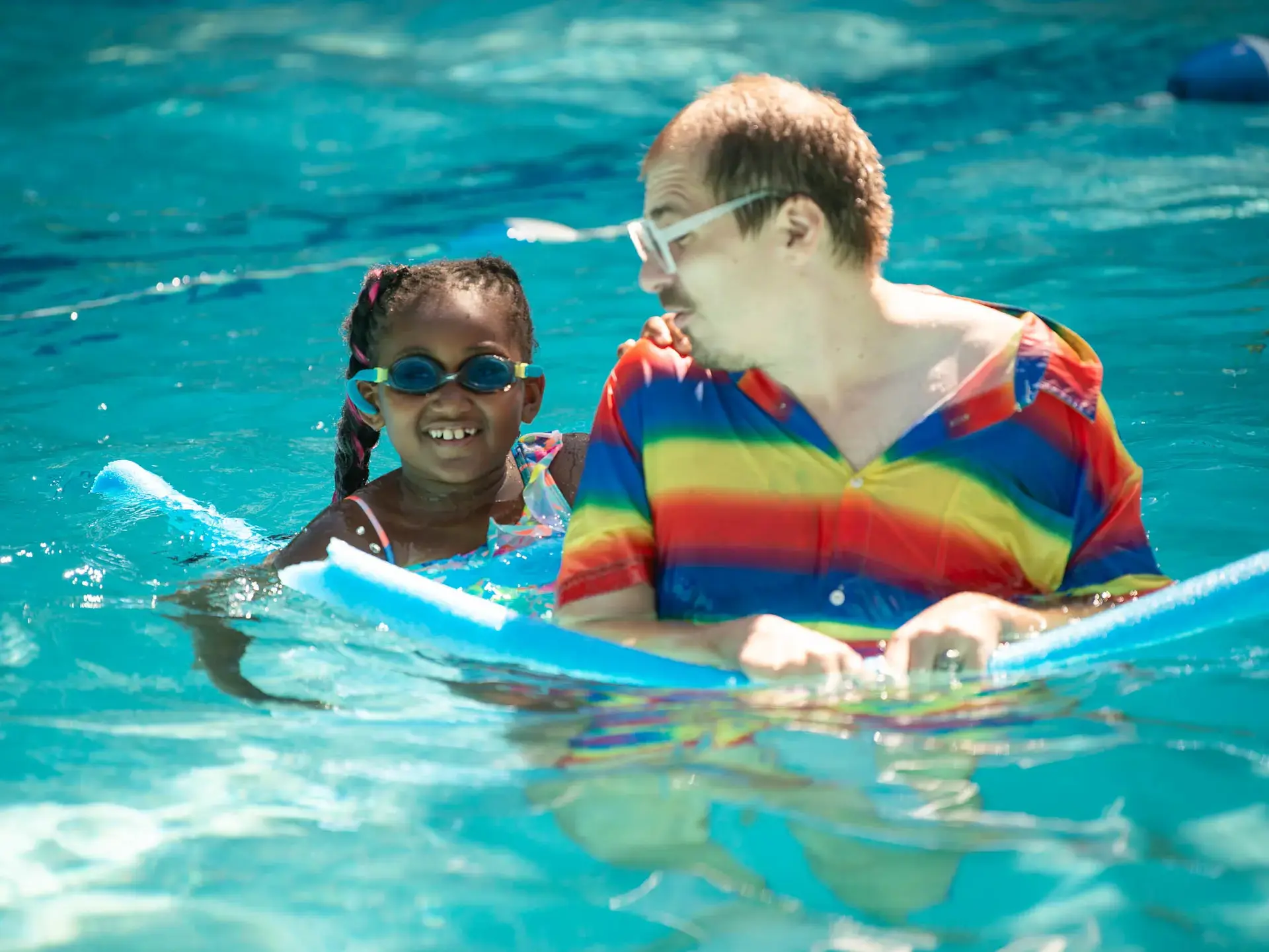 Child and adult on floater in pool